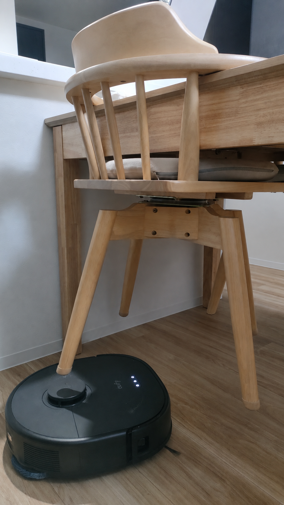 テーブルに掛けたダイニングチェアの下を通るEufy X10 Pro Omni